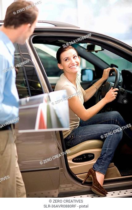 Woman admiring car in showroom