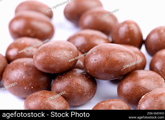 Brown dragee, in chocolate covered. White background. Close up