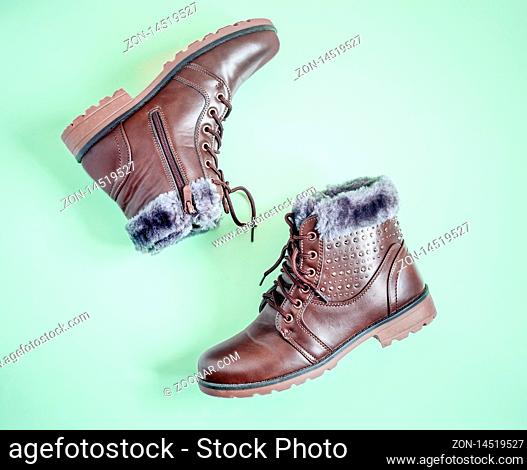 Comfortable and warm winter boots with gray fur inside, zipper and lacing. Presented on a light background. Top view, copy space