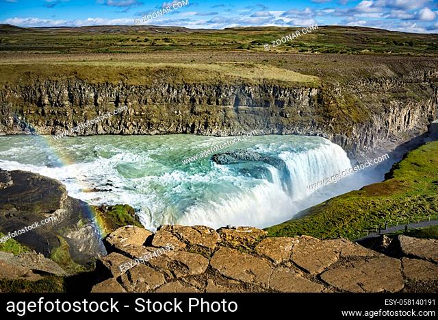 View of the great Gullfoss waterfalls and a spectacular rainbow in the canyon of Hvita river. Iceland