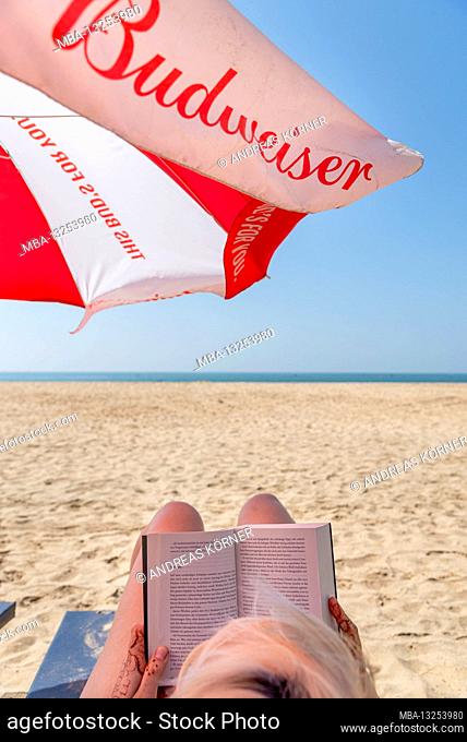 Woman reading a book on the beach, Agonda Beach, Goa, India