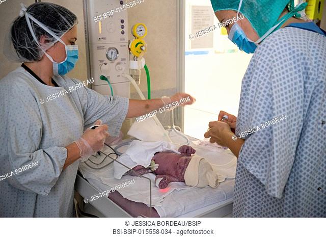 Reportage in the maternity service of Métropole Savoie hospital in Chambéry, France. A planned cesarean delivery. Intubation and placing a mask on the baby to...