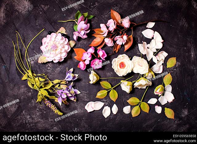 Various handmade flowers from foamiran foam top view on the black background