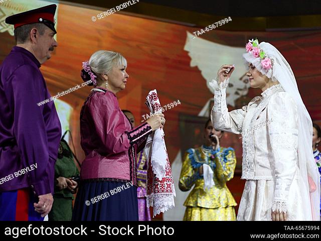 RUSSIA, MOSCOW - 12 de diciembre de 2023: La novia Alexandra Semenenko (R) se ve en una boda Don Cossack durante la exposición internacional de Rusia Expo y...