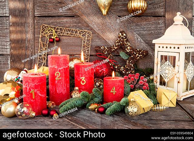 Rote Kerzen und Dekoration zu Weihnachten auf Hintergrund aus Holz