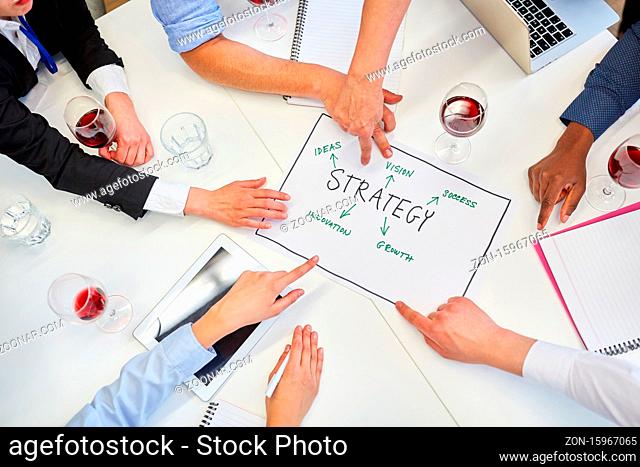 Hände von Geschäftsleuten zeigen auf einen Strategie Plan im Business Meeting