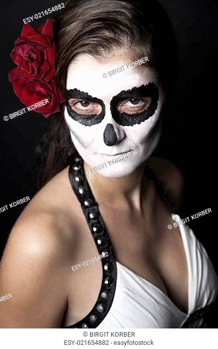 Woman with makeup of la Santa Muerte with red rose