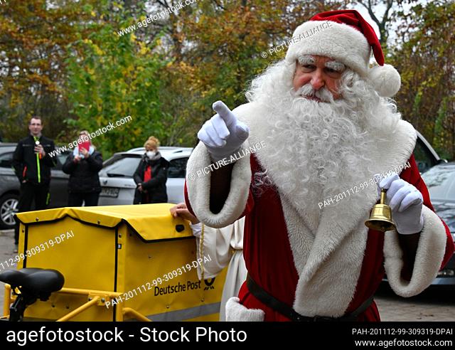 12 November 2020, Brandenburg, Himmelpfort: Santa Claus arrived in Himmelpfort on an electric bicycle from the German Post Office and rang a bell