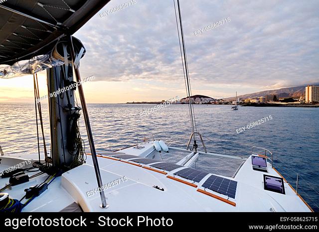 Luxury solar powered catamaran, fully sustainable and powered by solar energy, charging batteries aboard a sailboat, vessel in ocean waters, nobody
