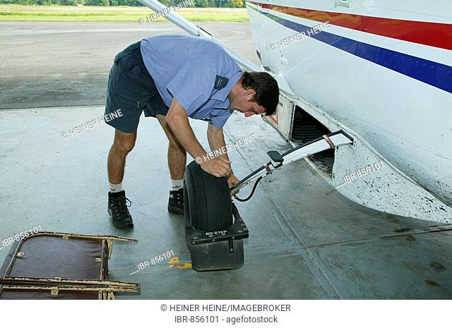 Aid organisation pilot checking his plane, Madang, Papua New Guinea, Melanesia