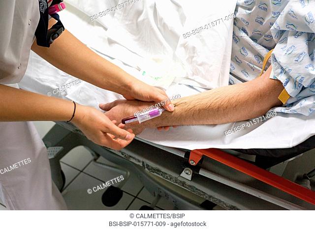 A nurse takes the blood of a patient in emergencies department in the hospital of Une infimière prélève le sang d'un patient au service des urgences du centre...