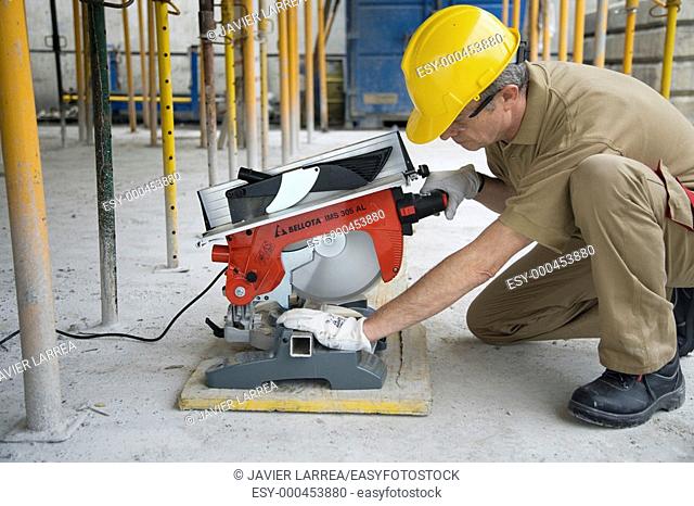 Construction worker cutting aluminum with electric cutter