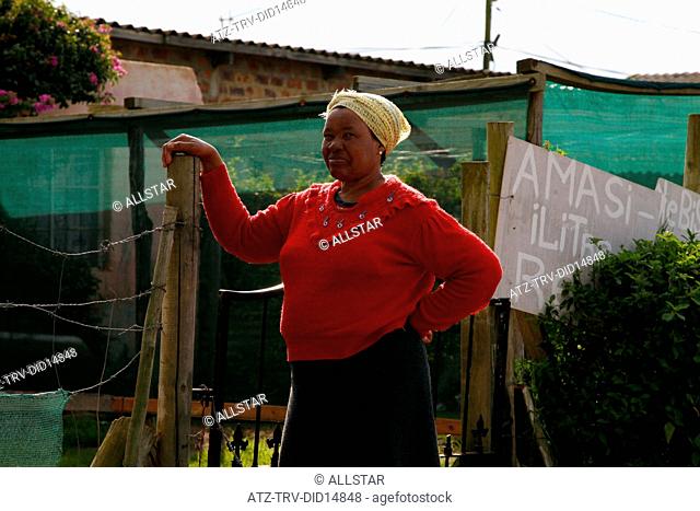 AFRICAN WOMAN IN RED CLOTHS; KNYSNA, TOWNSHIP, SOUTH AFRICA; 05/07/2011