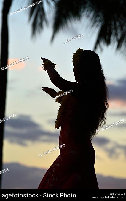 A silhouette of a hula dancer at sunset in Hawaii