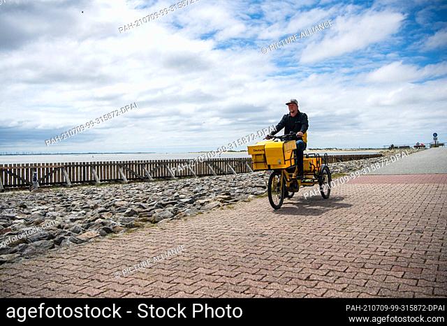 FILED - 24 June 2021, Lower Saxony, Baltrum: Andre Krandick, postman, distributes letters and parcels on the East Frisian island of Baltrum