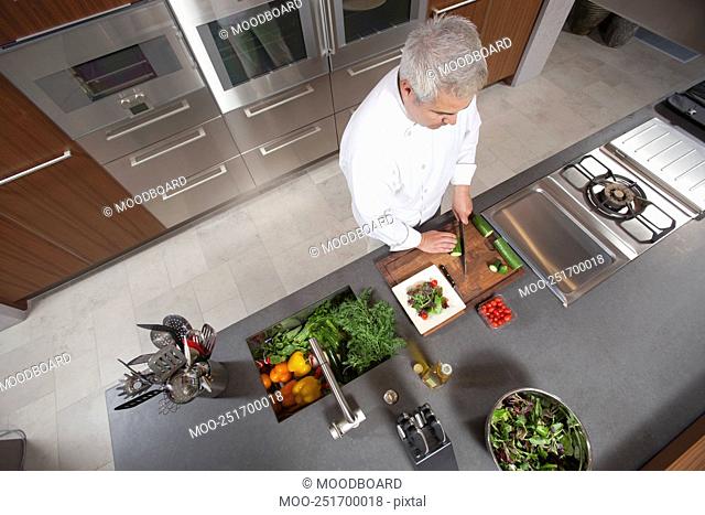 Mid- adult chef prepares salad overview