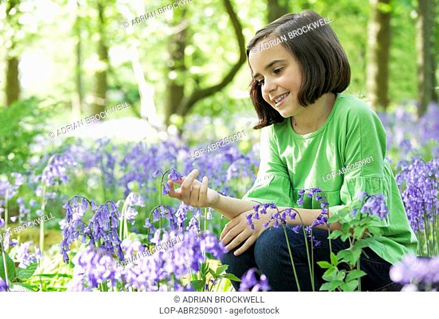 England, Buckinghamshire, Stokenchurch, Young girl sitting in a wood full of Bluebells