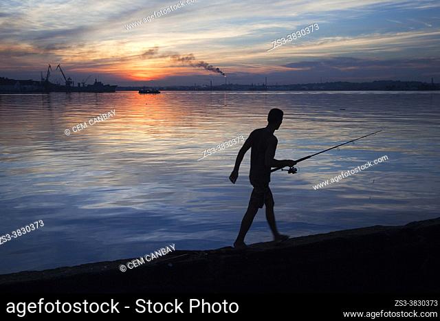 Silhouette of a fisherman on the water promenade Malecon in Old Havana-Habana Vieja early in the morning, La Habana, Cuba, West Indies, Central America
