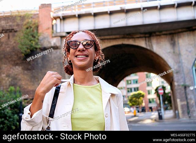 Happy woman with curly hair wearing sunglasses