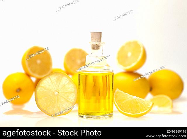 Lemon essential oil and lemon fruits on white background