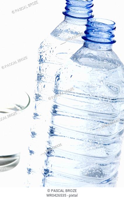 Close-up of two bottles of mineral water and a glass