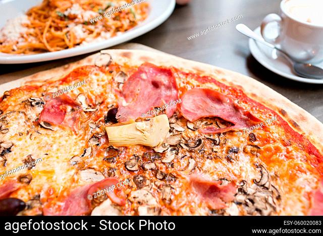 Pizza with artichoke, ham and mushrooms. the process of eating, cooking appliances