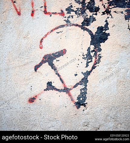Old grungy communism symbol graffiti on a wall, red color