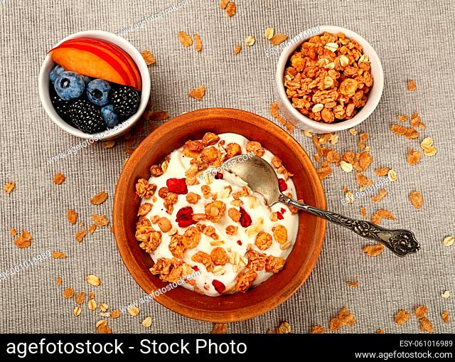 Close up portion of muesli granola breakfast with yogurt, fruits and berries, elevated top view, directly above