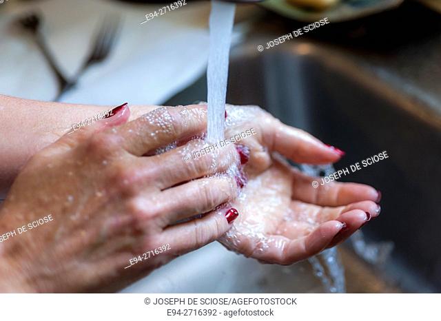 Woman's hands being washed over a sink