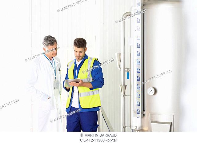 Worker and scientist talking in food processing plant