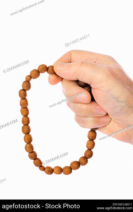 Hand with prayer beads isolated on white background
