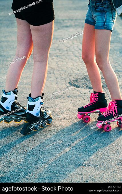 Teenage girls having fun rollerskating, spending time together on summer day