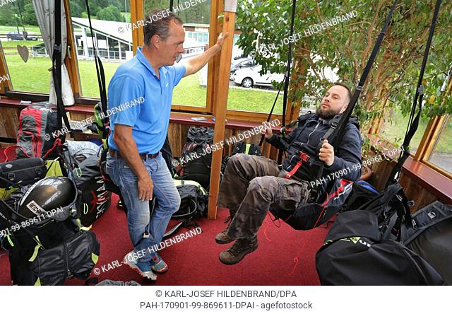 Paragliding teacher Harti Waitl gives out instructions to a pupil at his school near Schwangau, Germany, 30 July 2017. Photo: Karl-Josef Hildenbrand/dpa