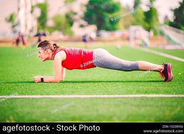 Theme sport and health. Young Caucasian woman doing warm-up, warming up muscles, training abdominal muscles. Losing belly