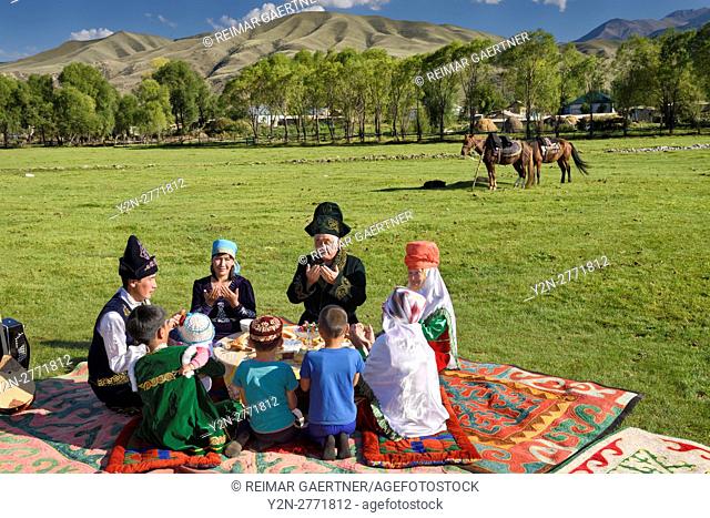 Traditional Kazakh family saying grace at a picnic in Chilik river valley Saty Kazakhstan