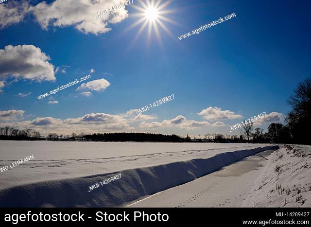 Winter landscape with lots of snow in Germany, beautiful blue sky and sun with sun rays