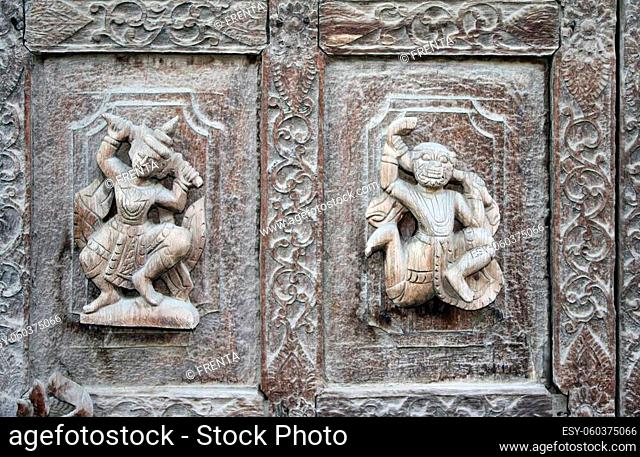 Detail of ancient wooden carved wall ornament with mythical hero and demon, Shwenandaw monastery (Golden Palace Monastery), Mandalay region, Myanmar, Indochina