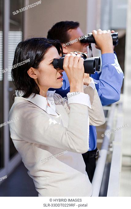Business people using binoculars
