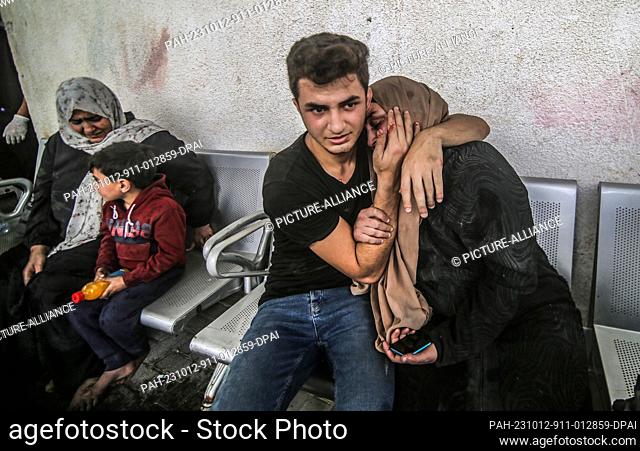 12 October 2023, Palestinian Territories, Rafah: A Palestinian comforts his mother at a hospital following an Israeli air strike as fighting between Israeli...