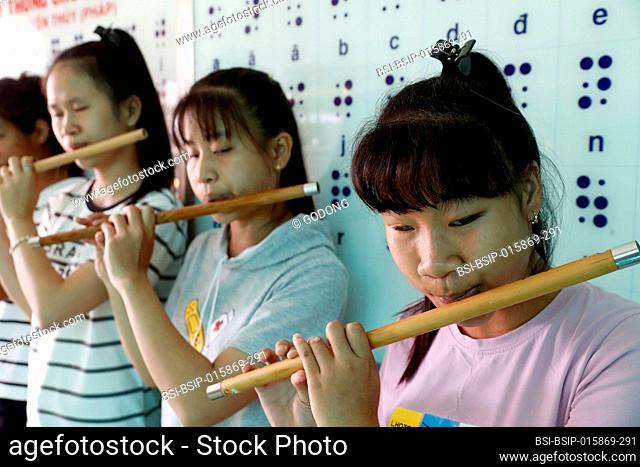 Center for blind children run by Children Action. Young girls playing music. Ho Chi Minh city. Vietnam