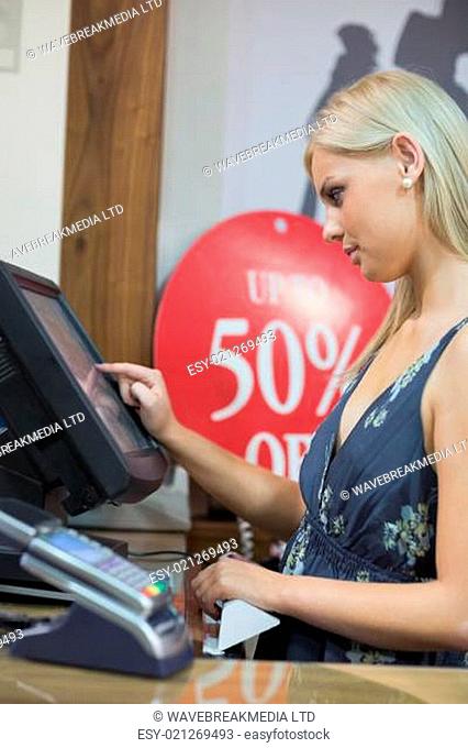 Woman is standing behind the counter of the shop while typing