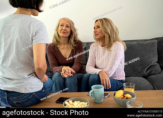 Three attractive senior ladies having a conversation at home