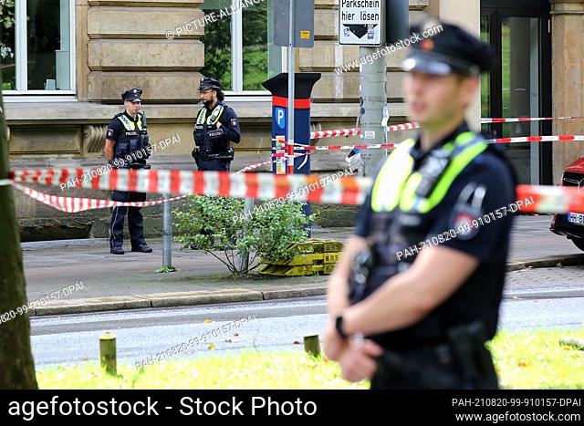 20 August 2021, Hamburg: Emergency forces stand at a police cordon on the Gorch-Fock-Wall. Witnesses heard shots in the center of Hamburg on Friday - a large...