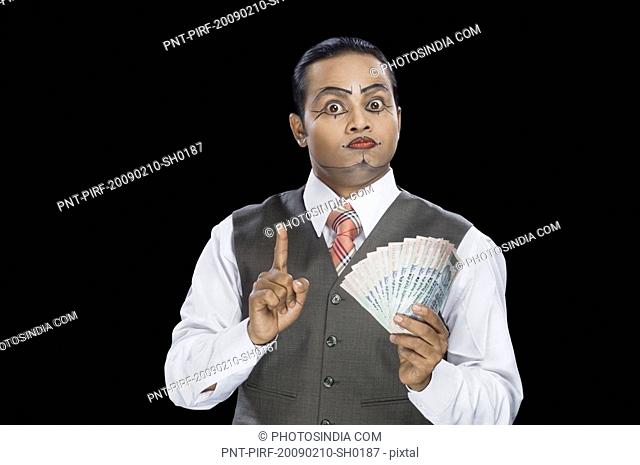 Close-up of a mime holding currency notes