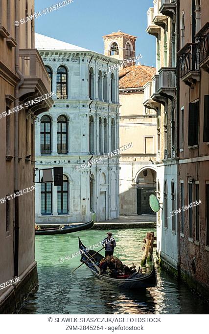 People enjoying a gondola ride on a canal in Cannareggio, Venice, Italy