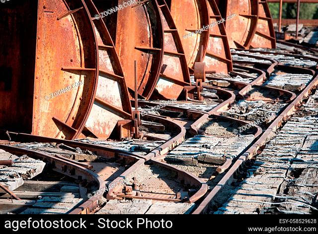 Details of rusty metallic transportation rail trail platform of an abandoned mine