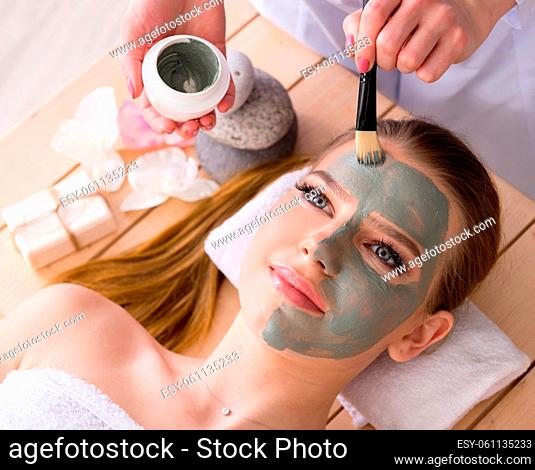 The young woman in spa health concept with face mask