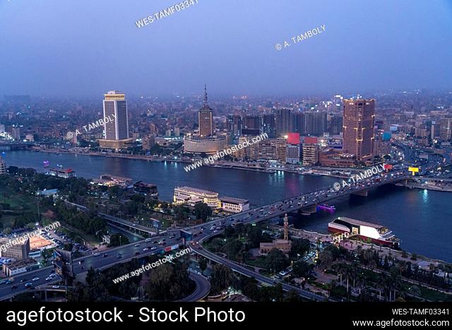 Egypt, Cairo, River Nile, Qasr El Nil Bridge and surrounding downtown buildings at dusk