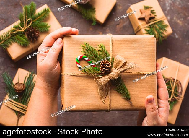 Female hands hold gifts in craft paper. Eco styled Christmas presents