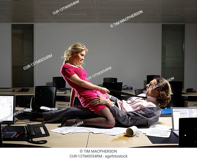 A couple embrace on an office table